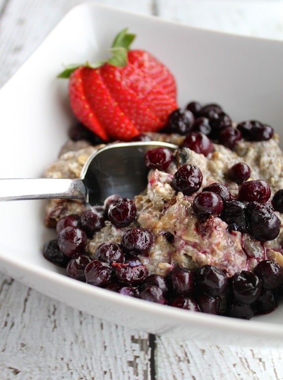 Bowl of oatmeal with blueberries and a strawberry