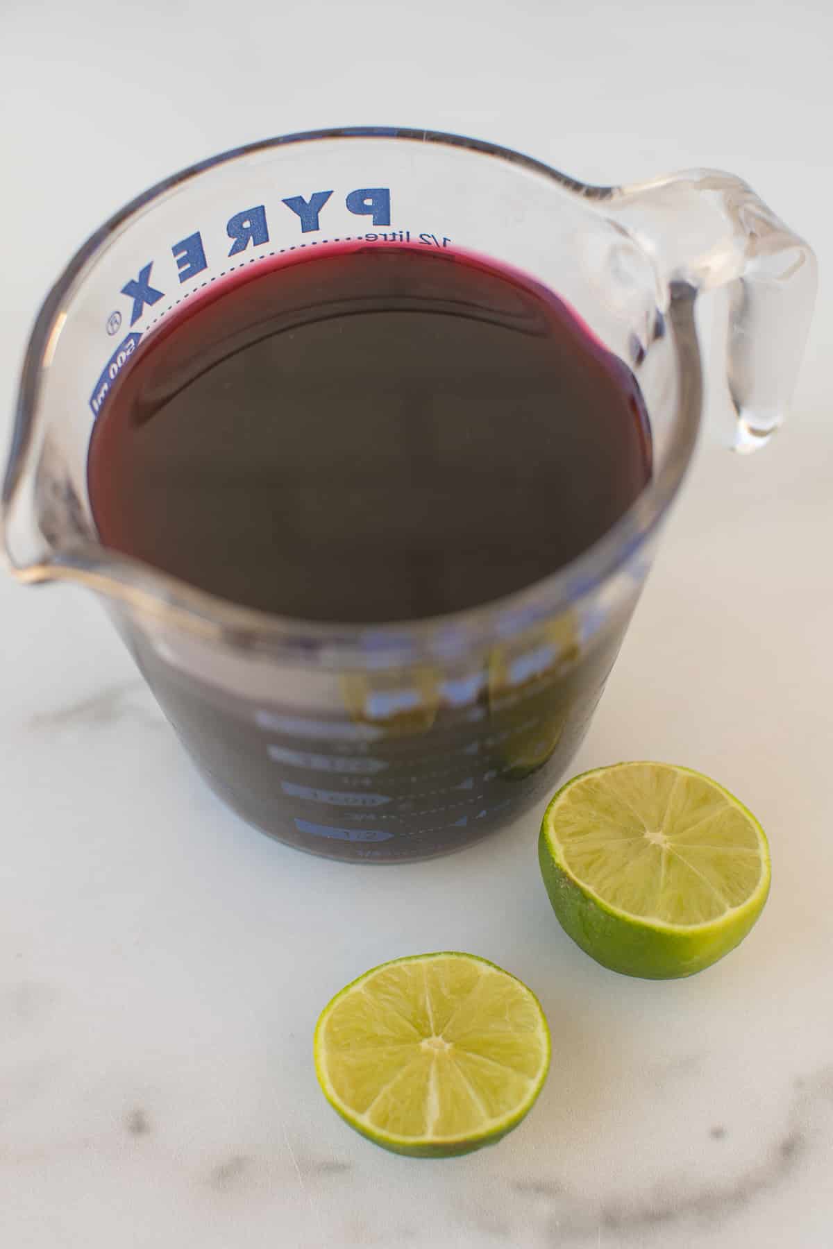 pyrex jar filled with pomegranate juice plus a lime.