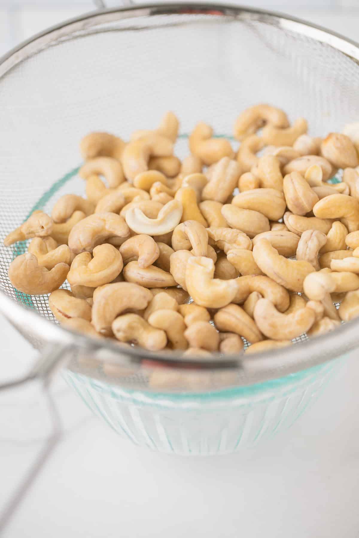 cashews in a fine mesh strainer