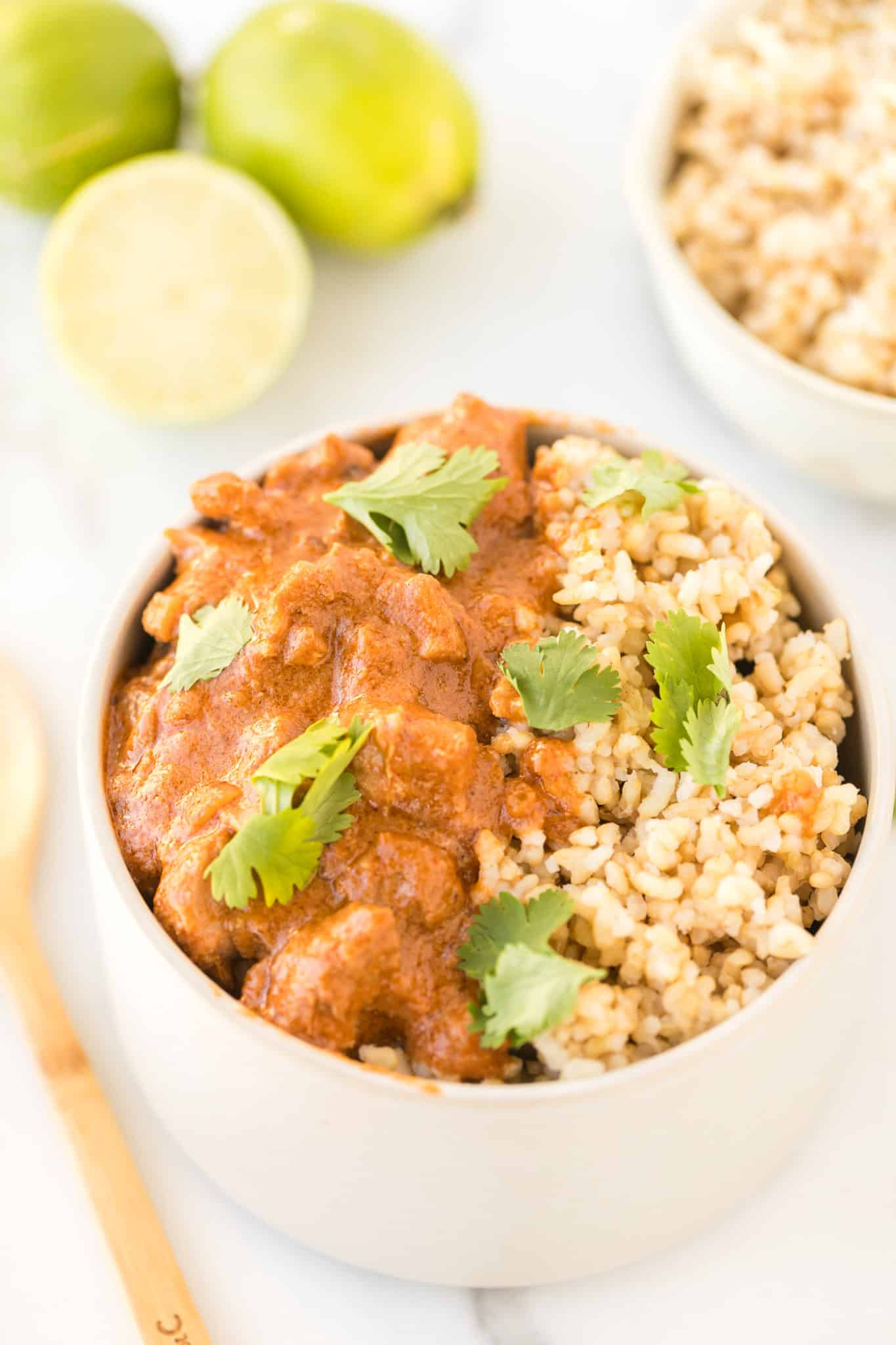 instant pot peanut chicken served with brown rice in a bowl.