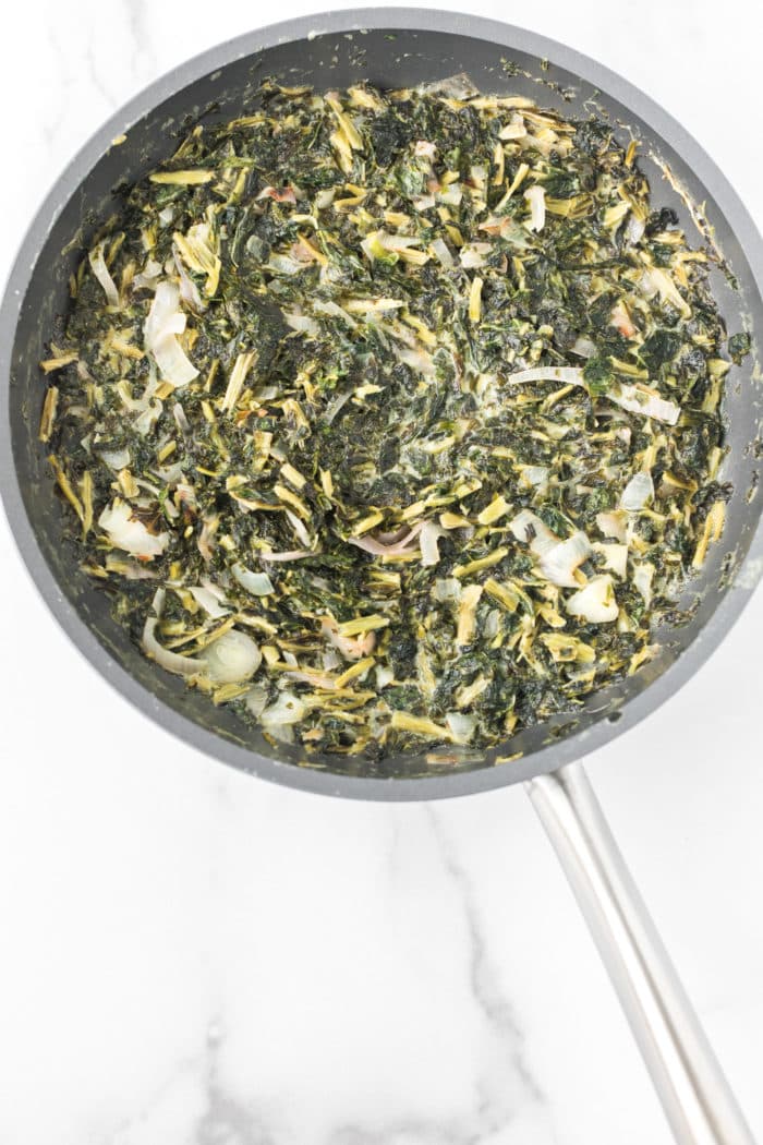 creamed kale with onion in a skillet