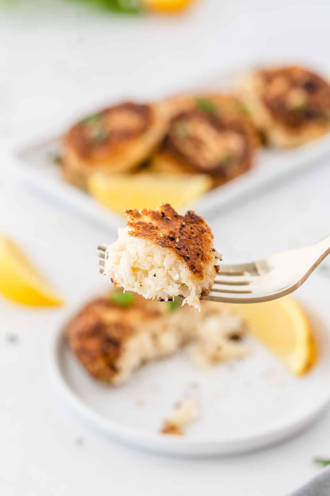fork up close with a bite of crab cake on it to show texture.