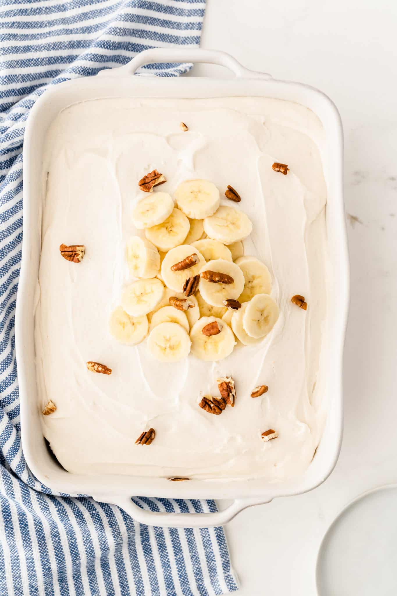 banana cake with frosting and sliced banana on top.