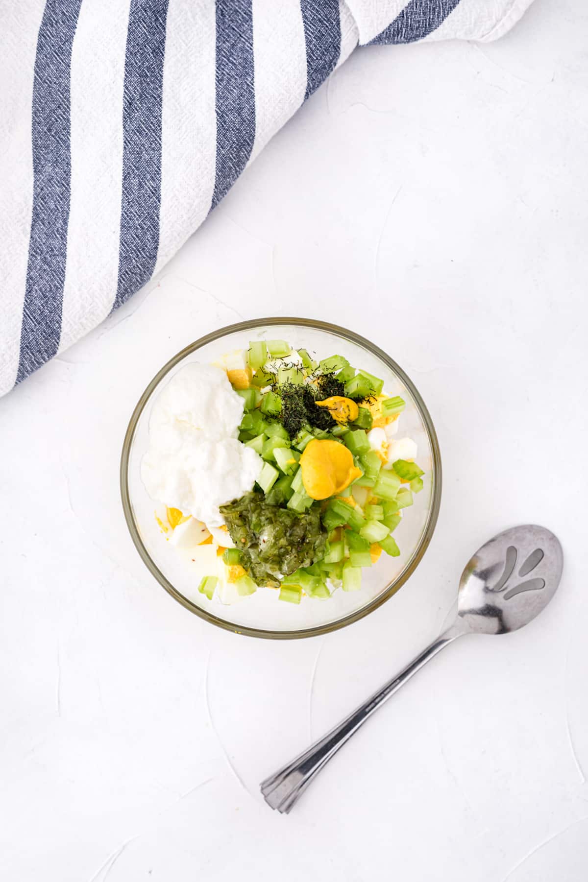 A bowl of ingredients for egg salad.