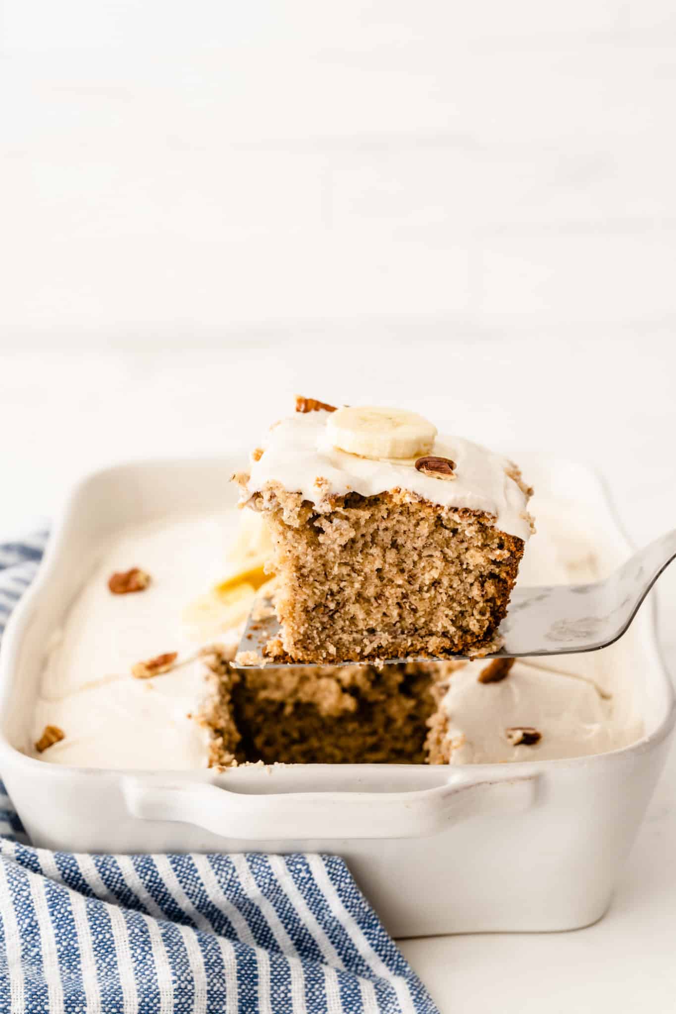 A slice of gluten-free banana cake with vanilla frosting.