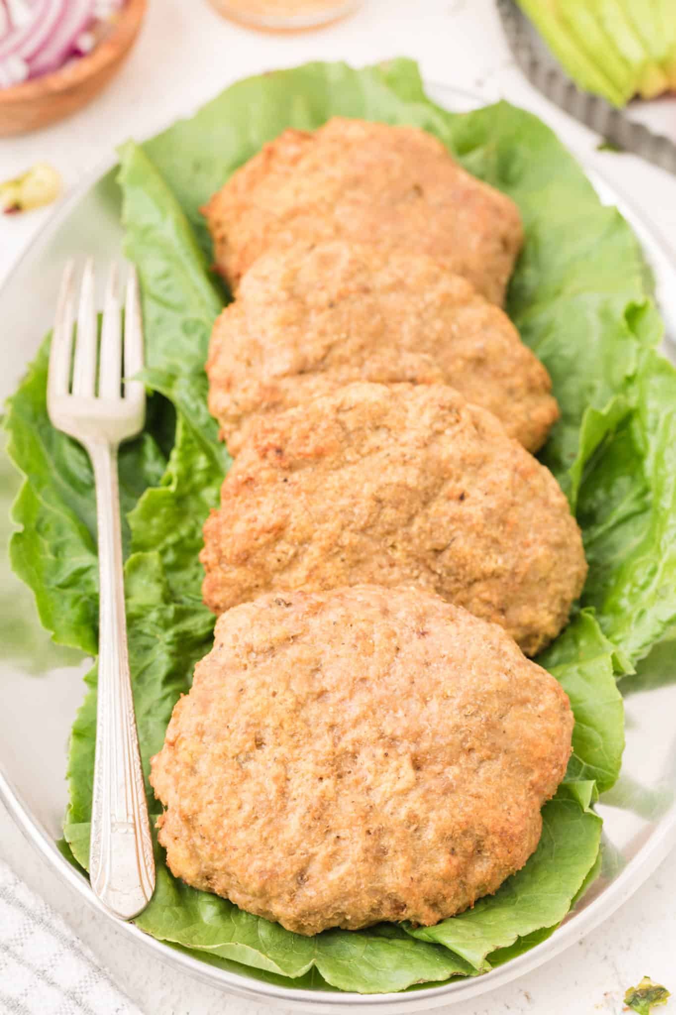 four air fried turkey burger patties served on a tray.