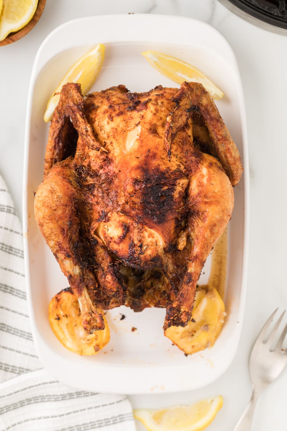 Air fryer roast chicken in a serving dish.