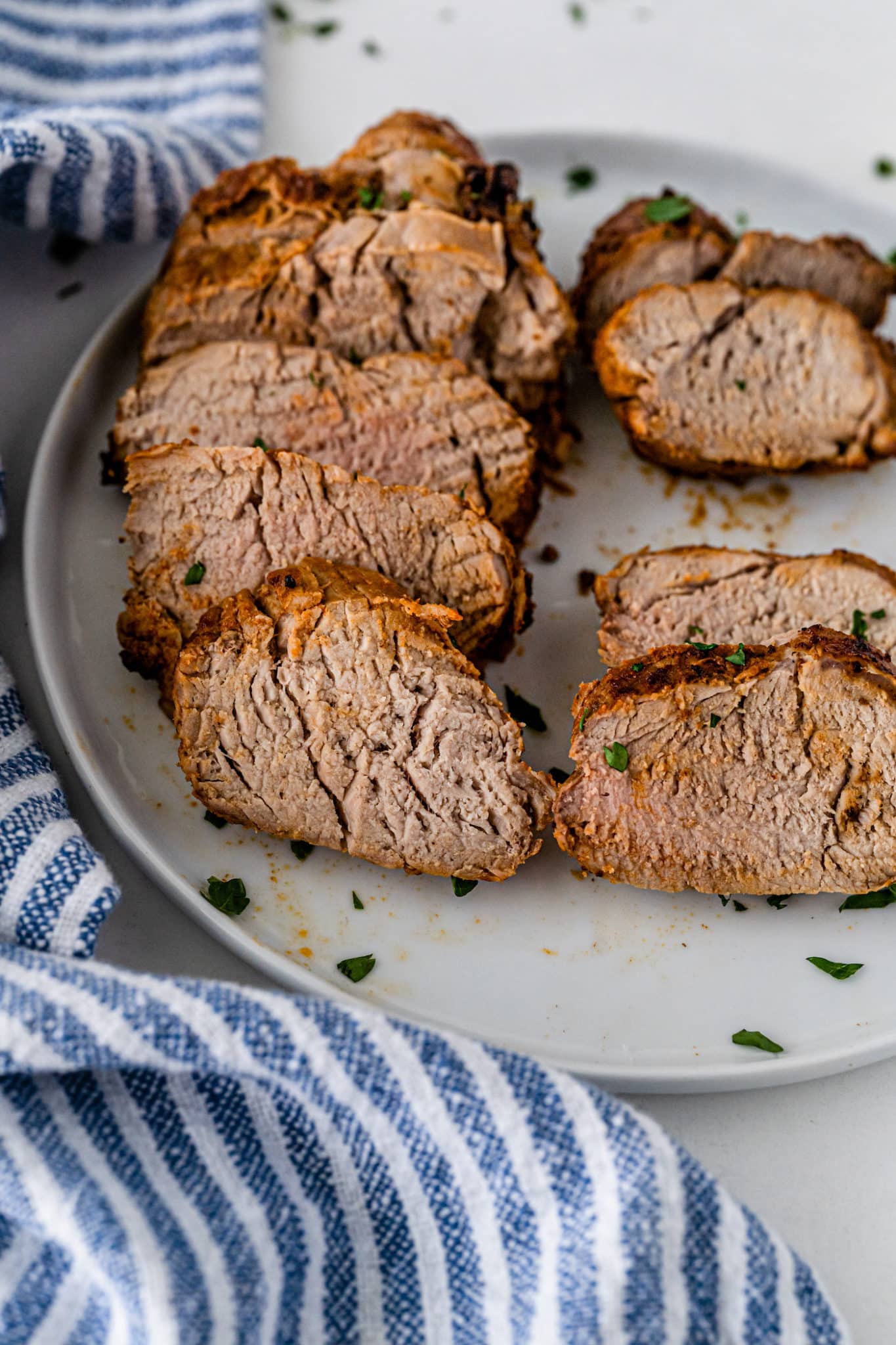 sliced air fried pork loin roast on serving plate.