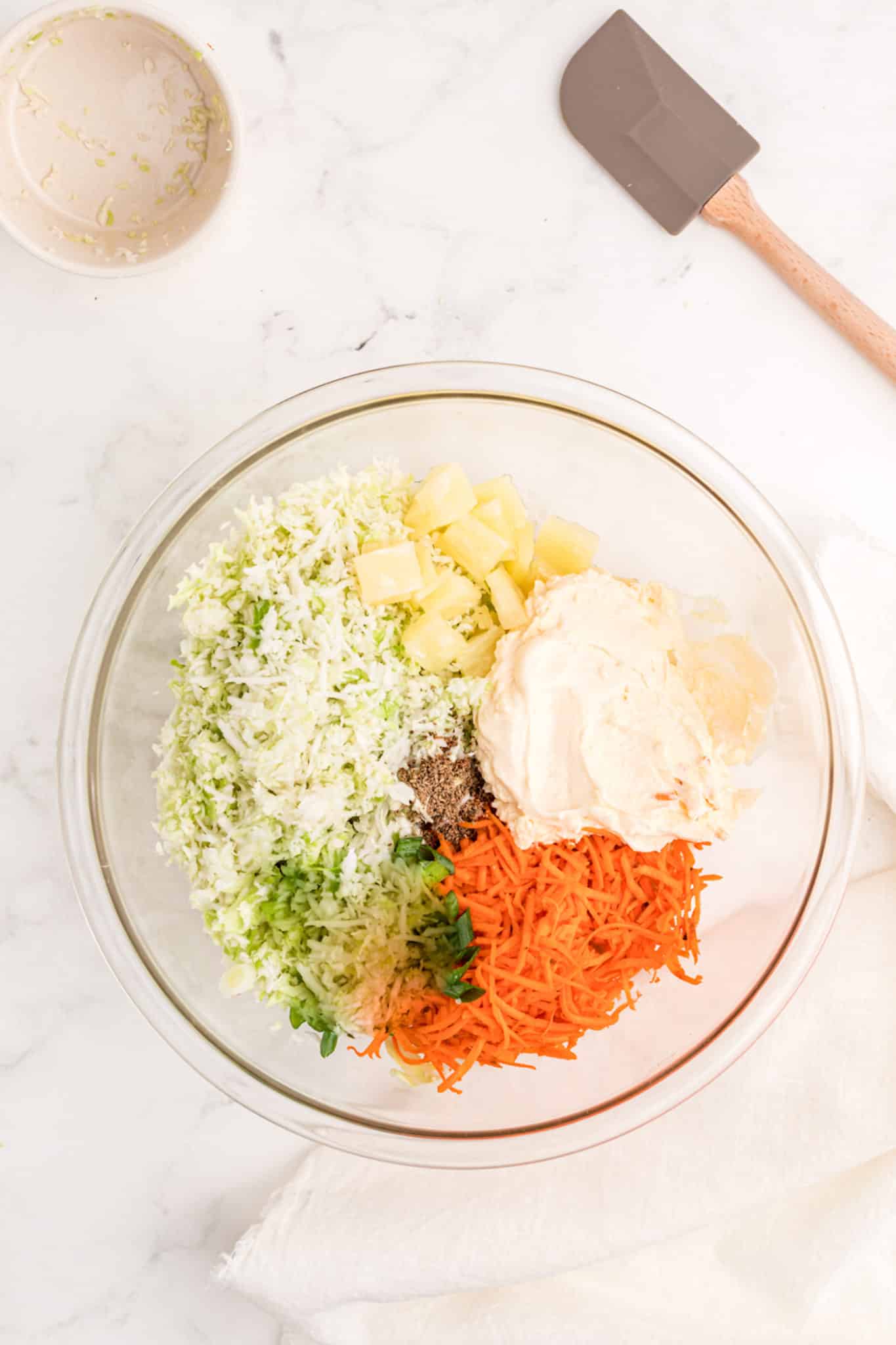 carrots, cabbage, pineapple, and mayonnaise in a bowl.
