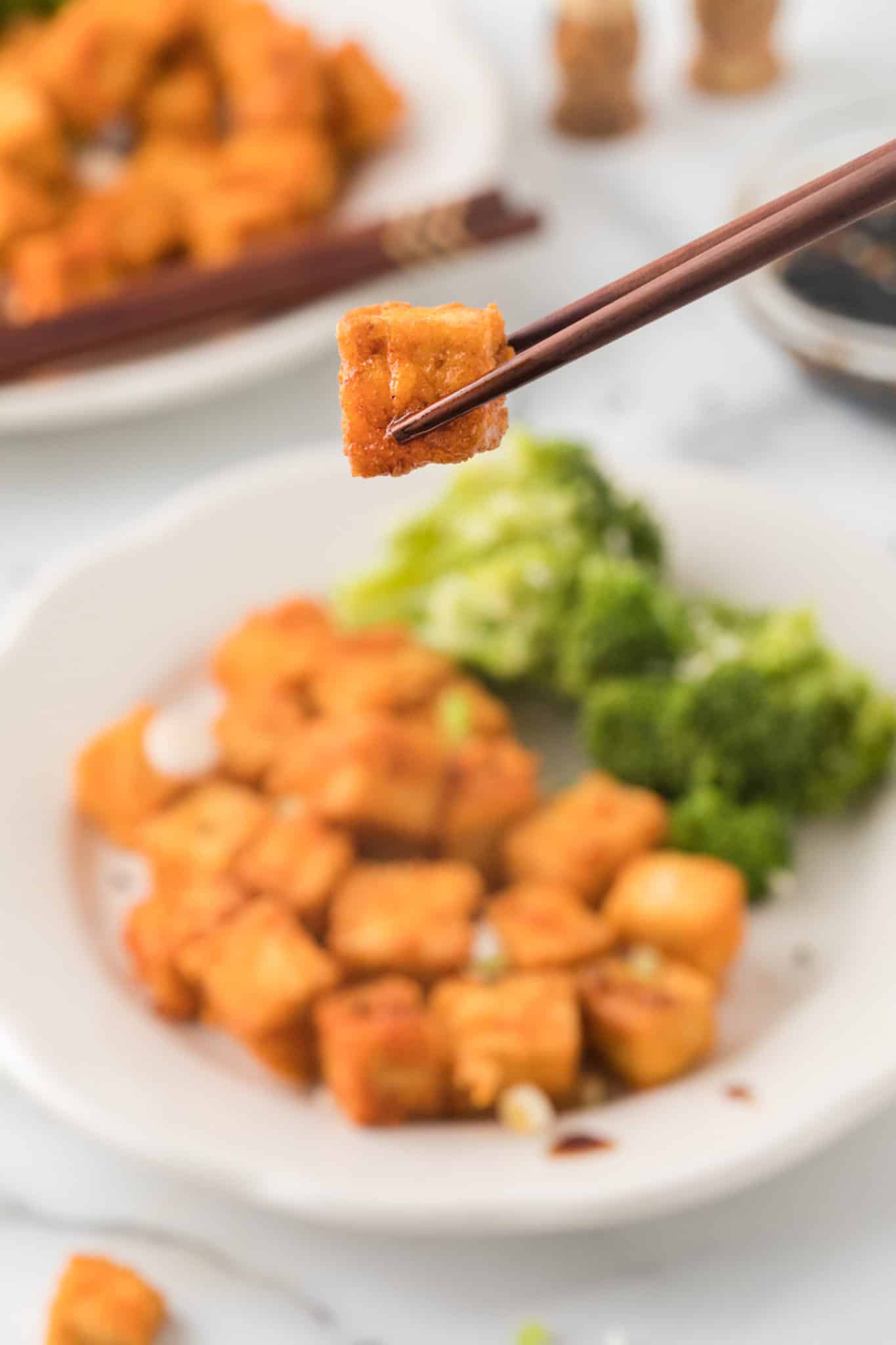 piece of tofu served with chopsticks.