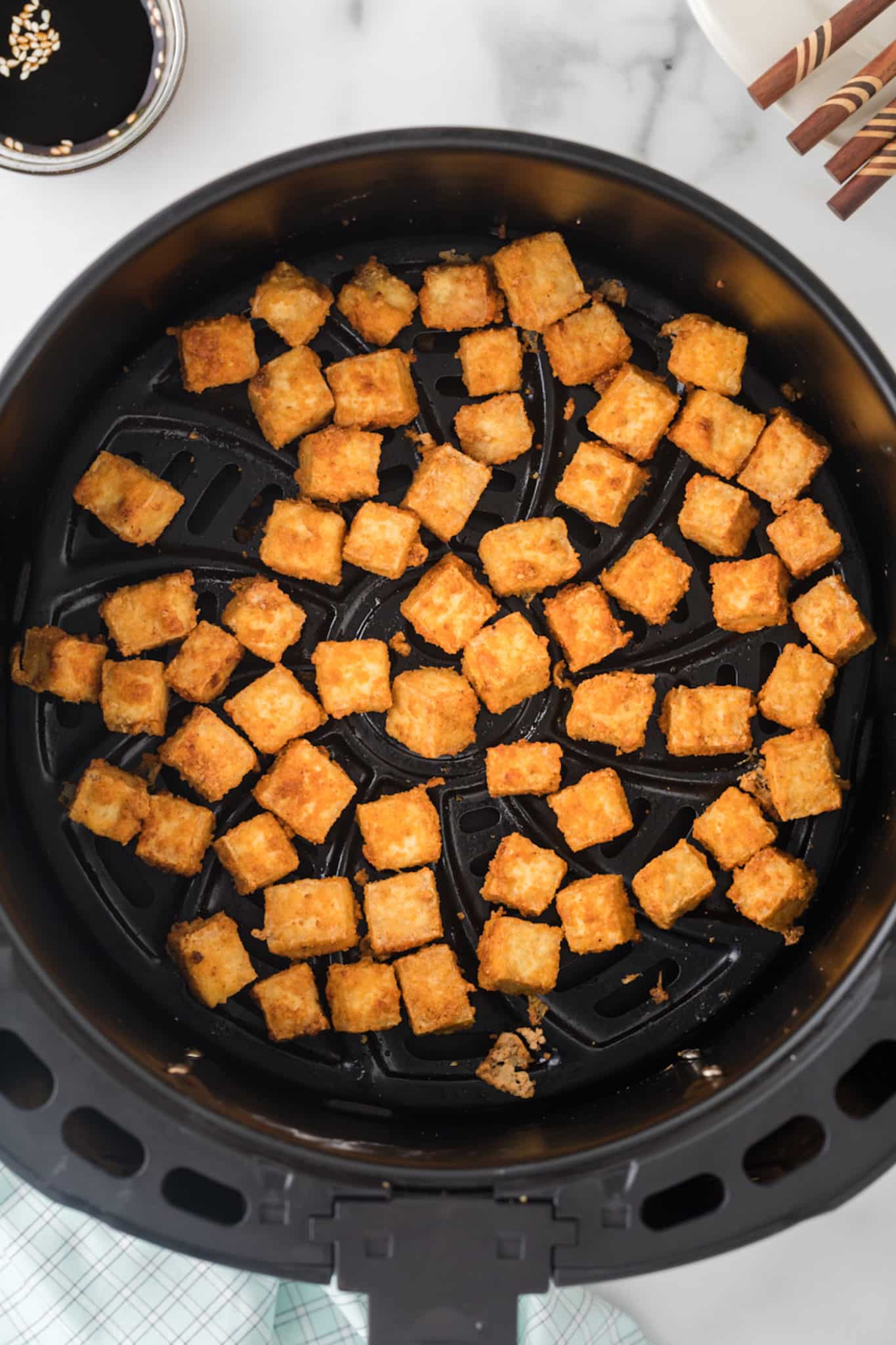 crispy tofu in air fryer basket.