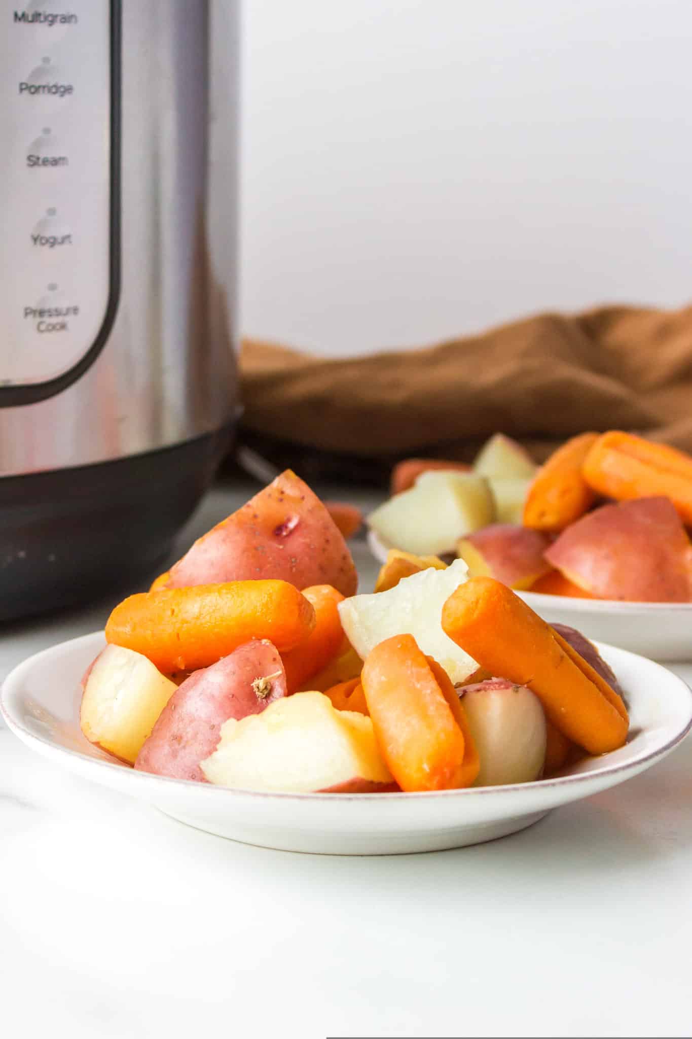 plate with instant pot cooked potatoes and carrots.