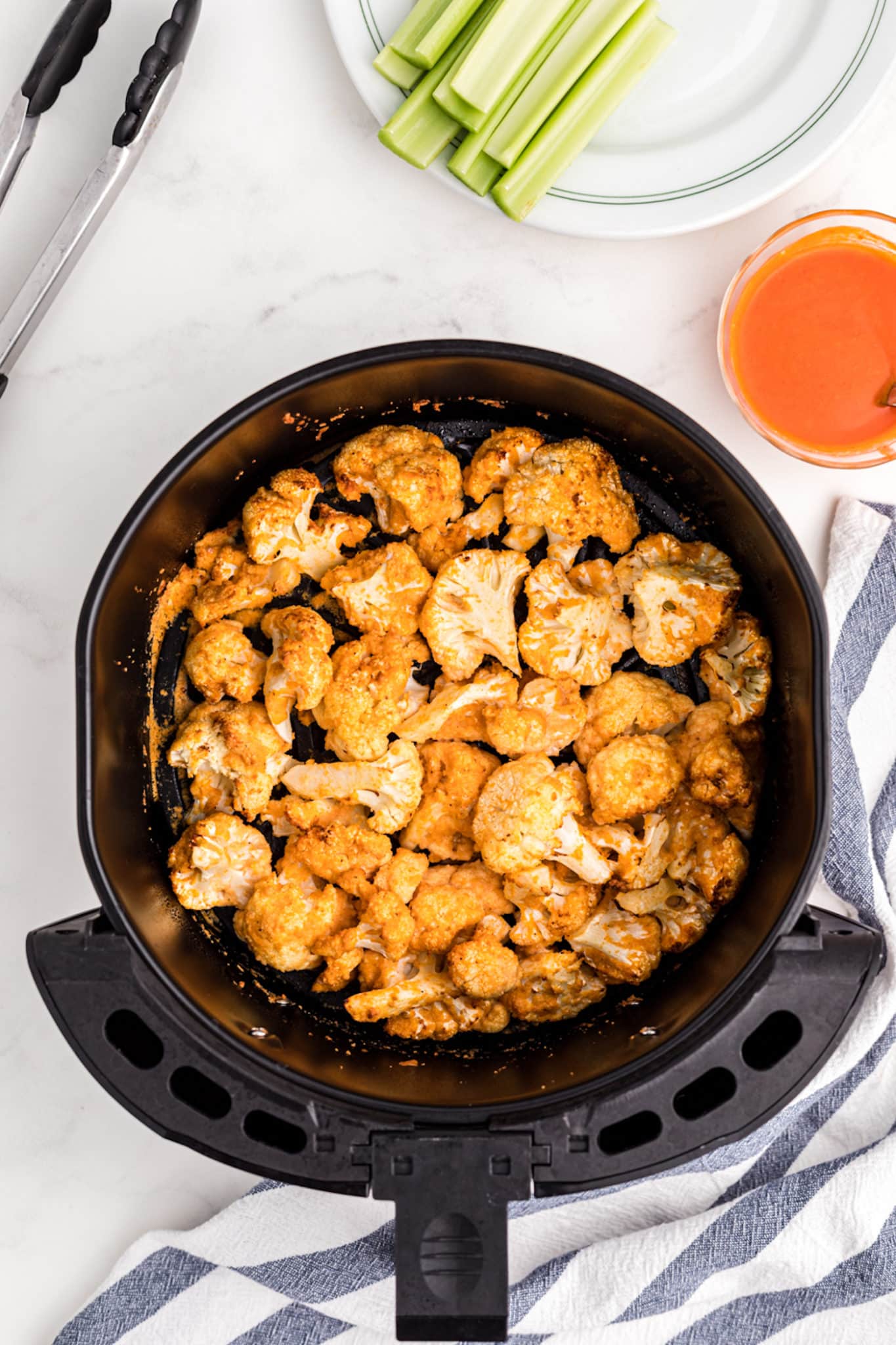 cauliflower florets in air fryer basket.