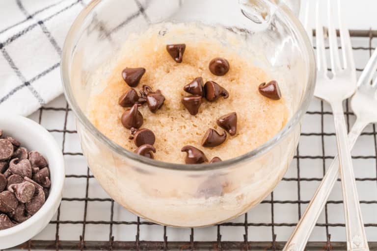 vegan mug cake with chocolate chips on top with forks.