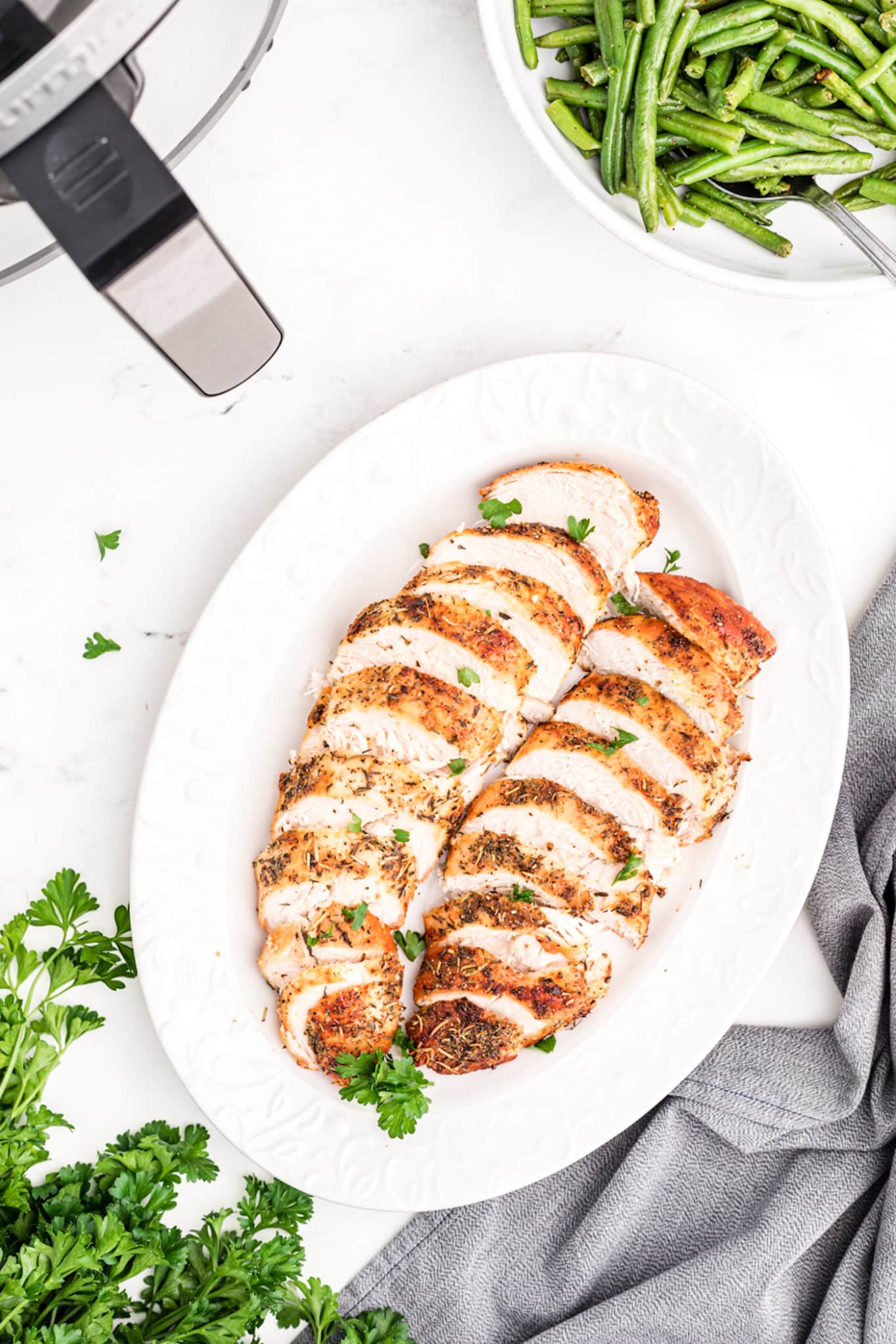 air fried turkey tenderloins sliced on a platter.