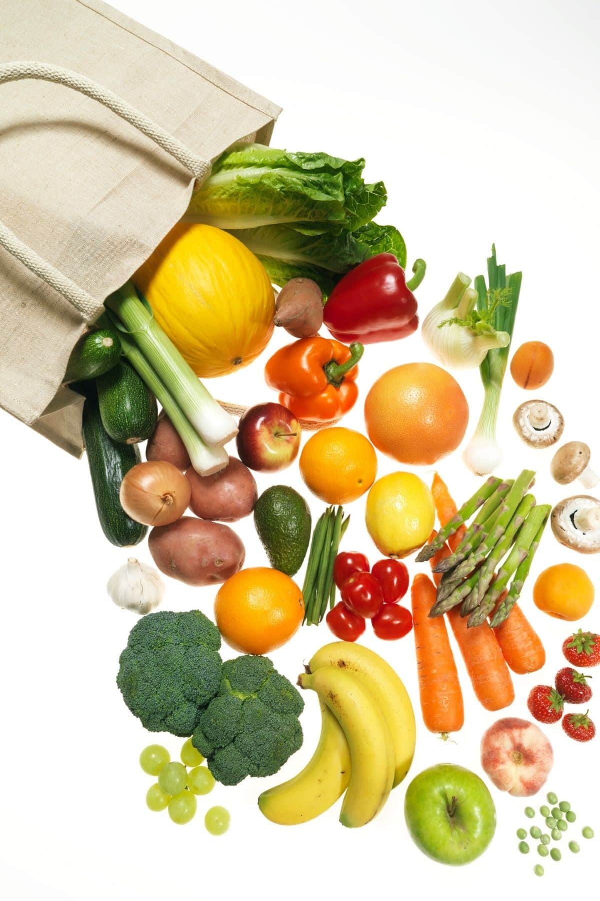 a bag of fruits and vegetables spilling onto a counter.