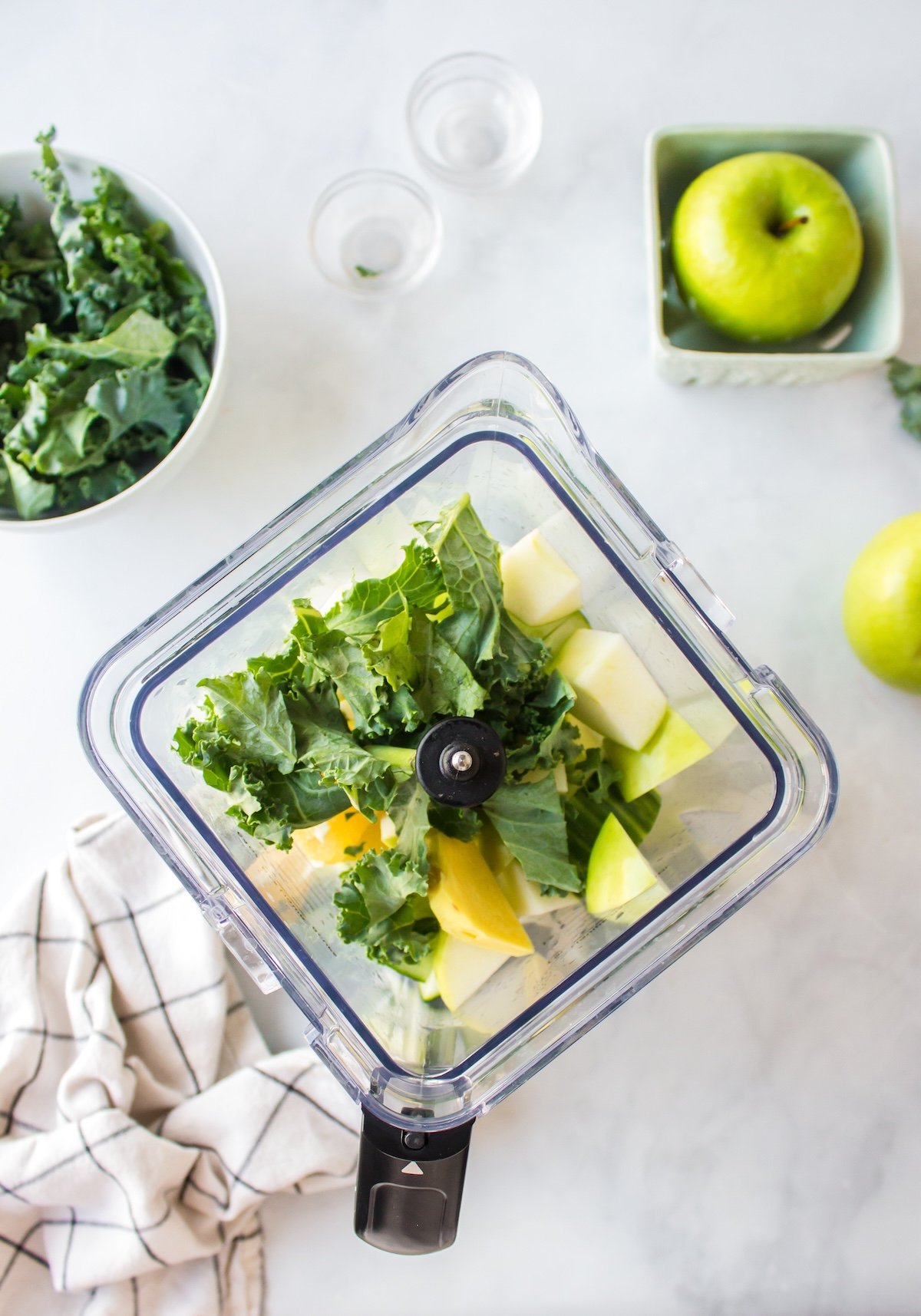 overhead shot of kale juice ingredients in blender pitcher.