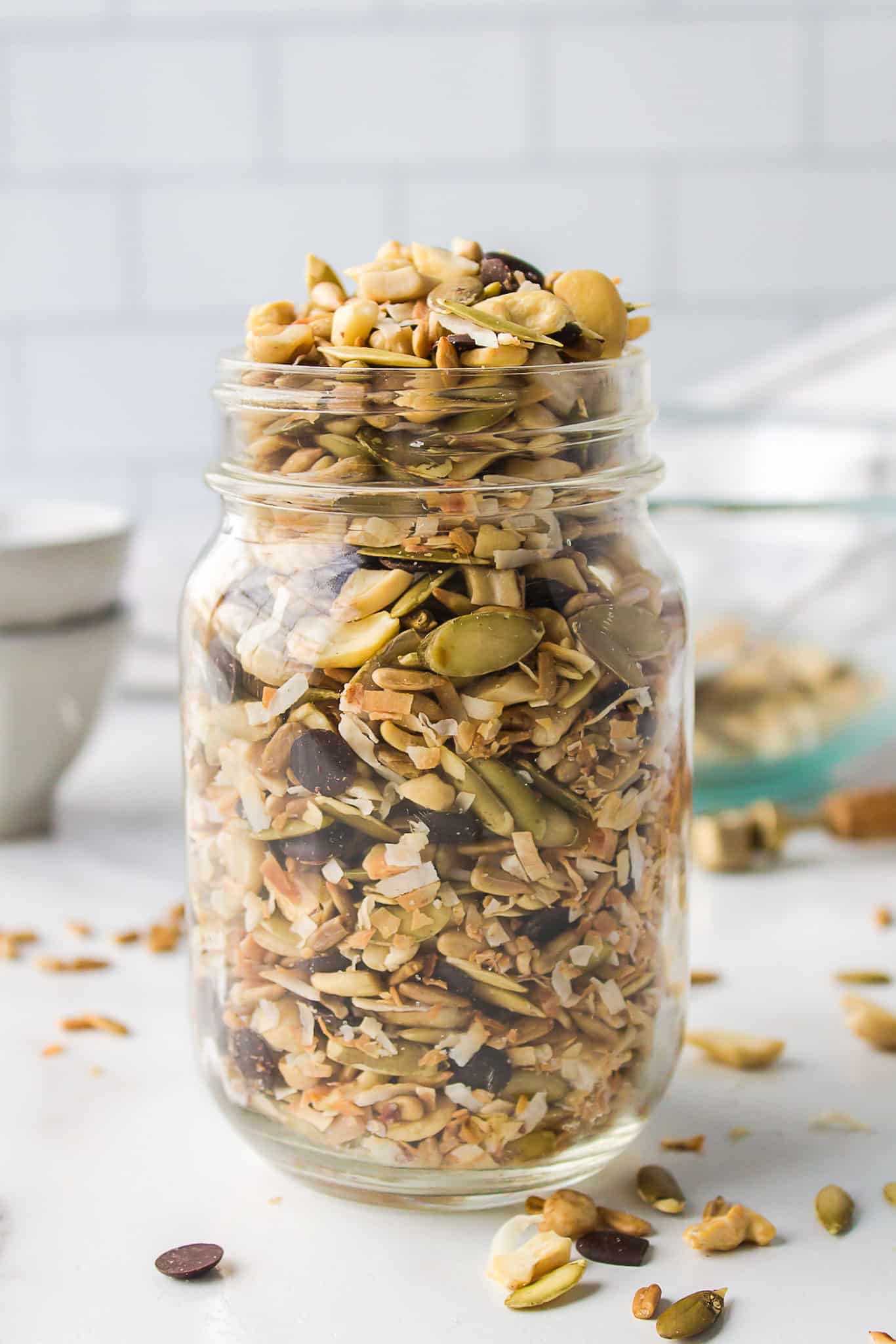 a jar of trail mix with seeds and chocolate chips.