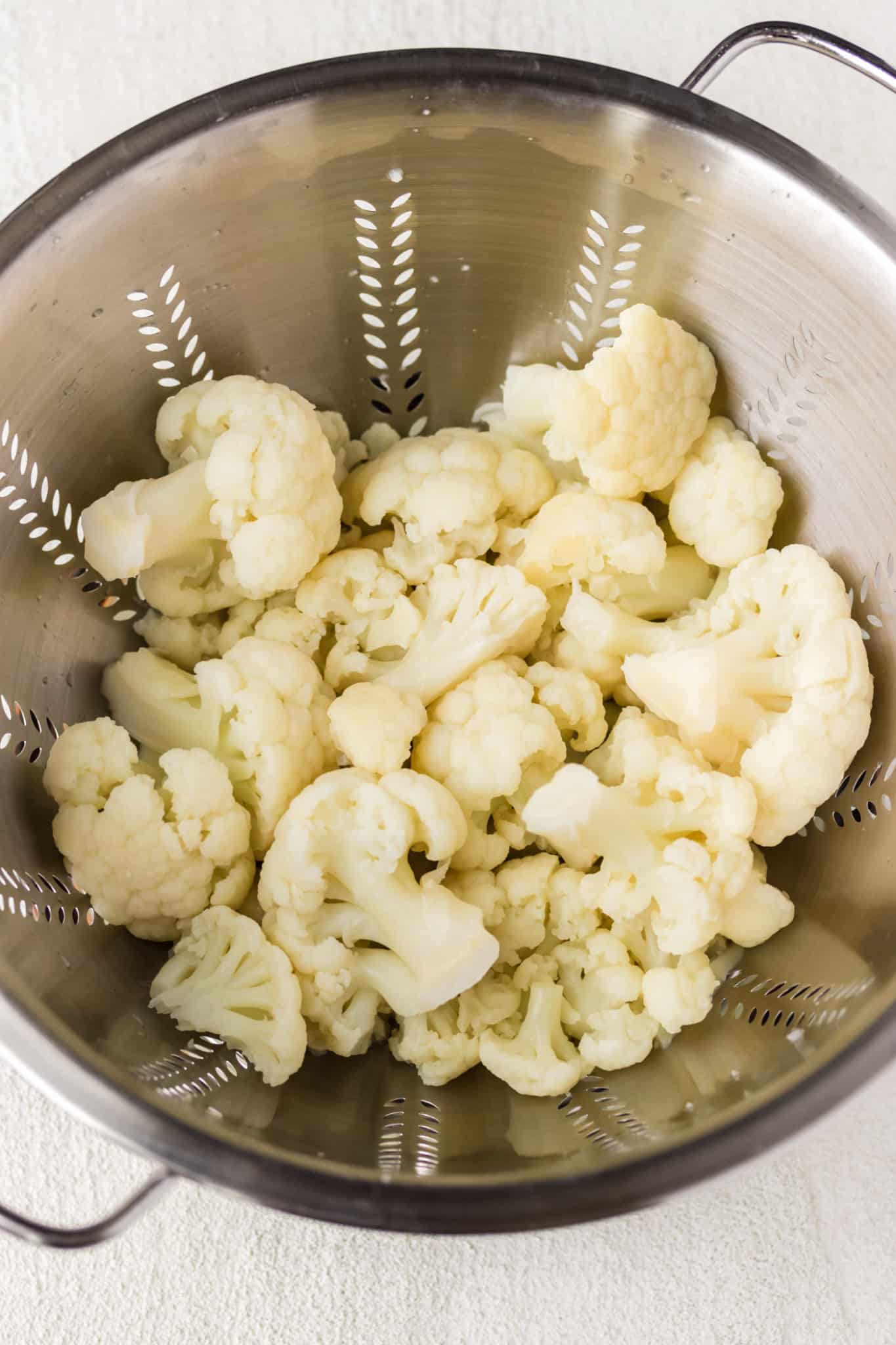 steamed cauliflower drained in a colander.