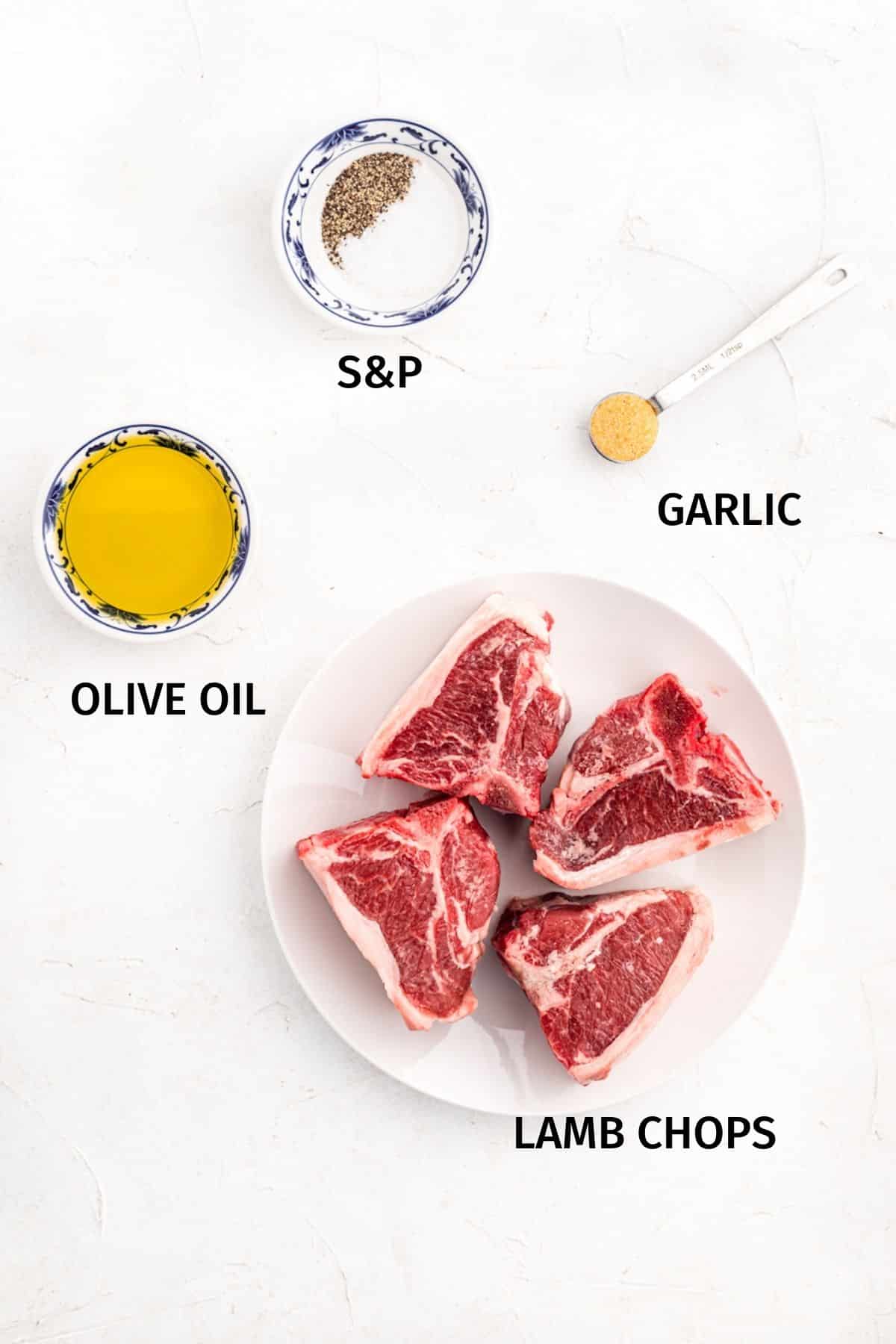 Ingredients to make air fryer lamb chops set out on a white surface.