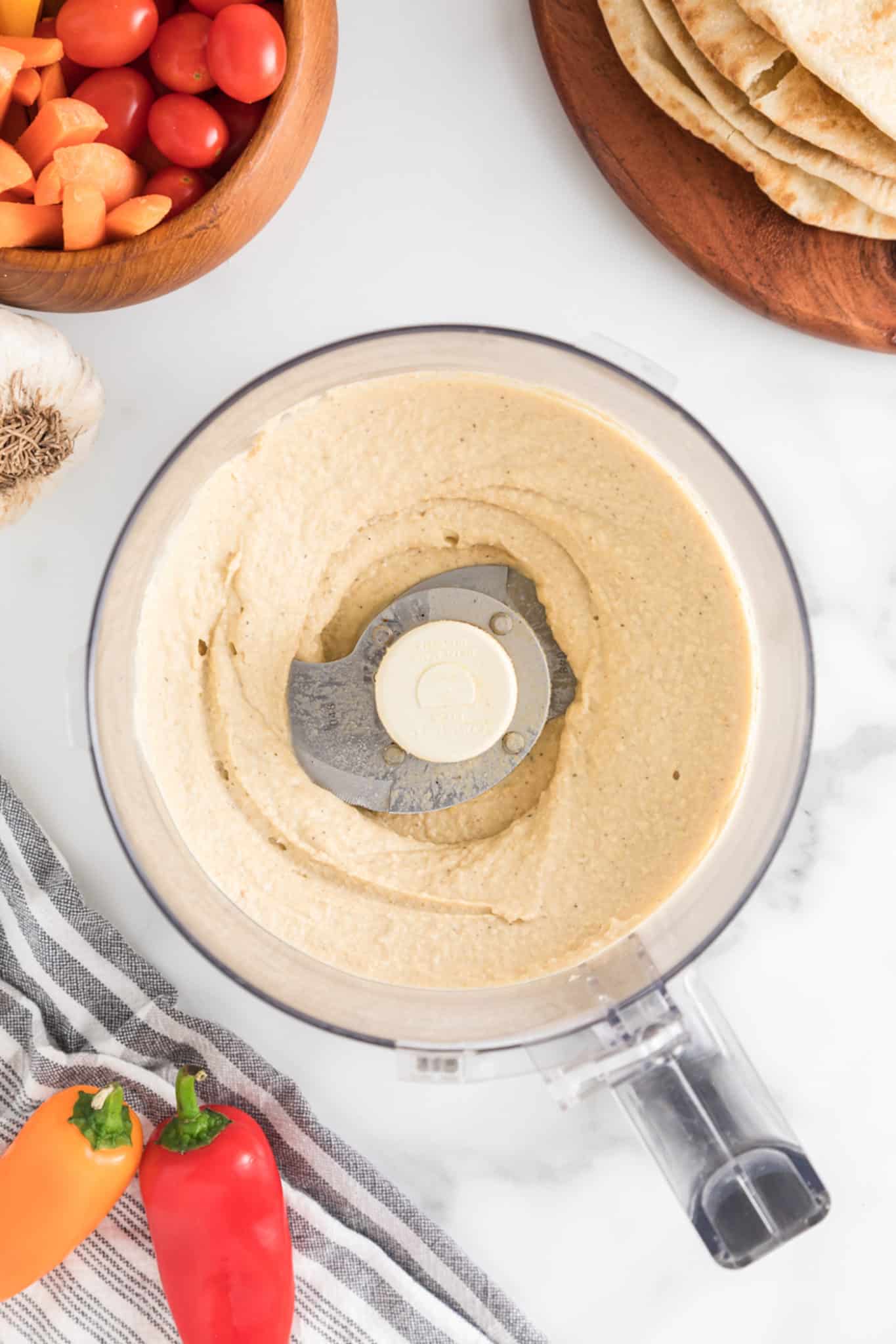 Completed homemade hummus in the bowl of a food processor.