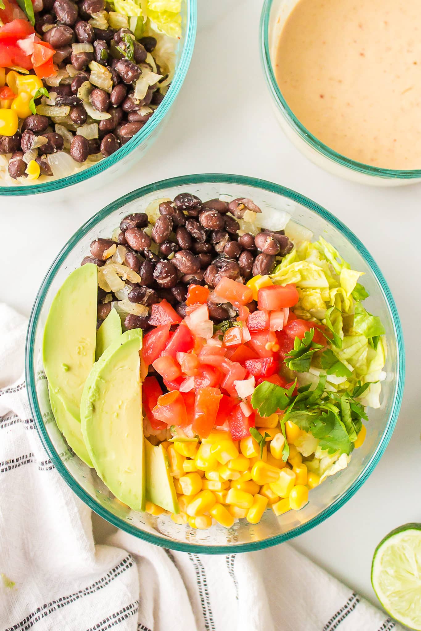 A clear glass bowl with a serving of Mexican brown rice Buddha bowl.