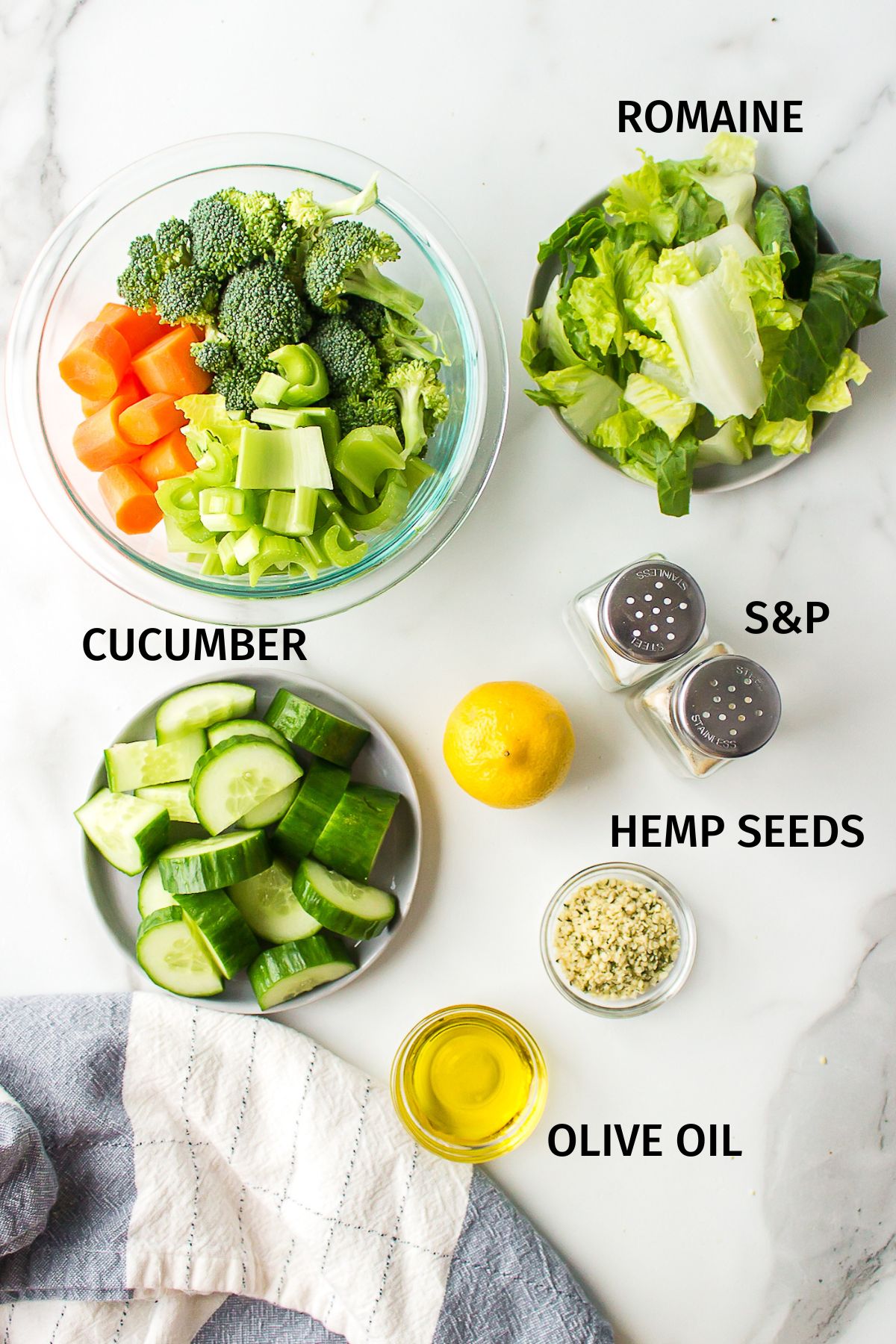 Ingredients for chopped veggie salad in small bowls on a white surface.