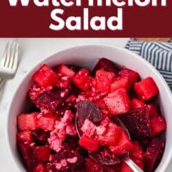 A spoon holding a bit of watermelon beet salad over a small white bowl.