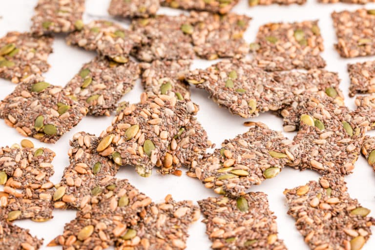 Homemade seed crackers on a white surface.