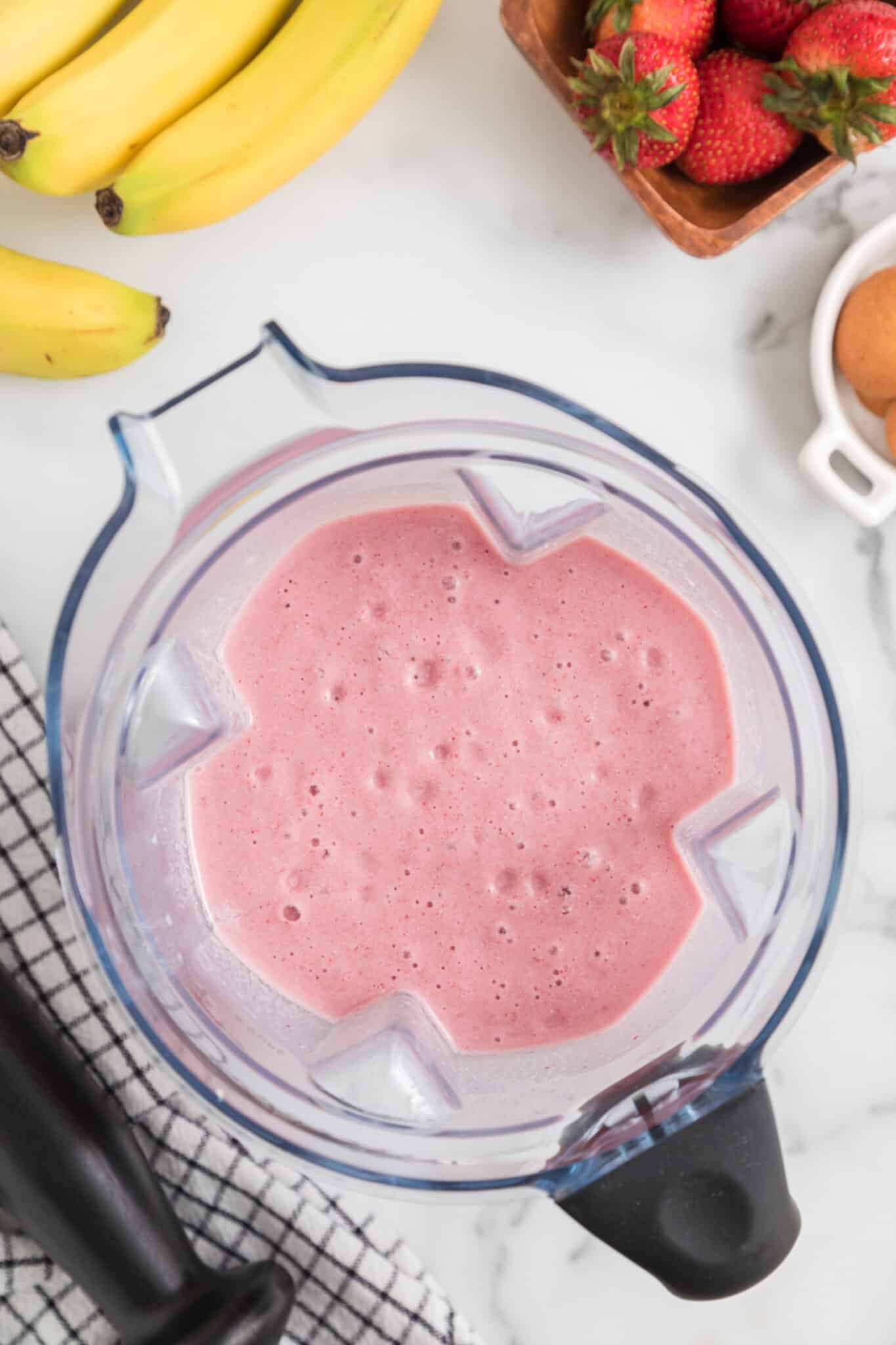 Top view of a blender jar full of pink blended smoothie.
