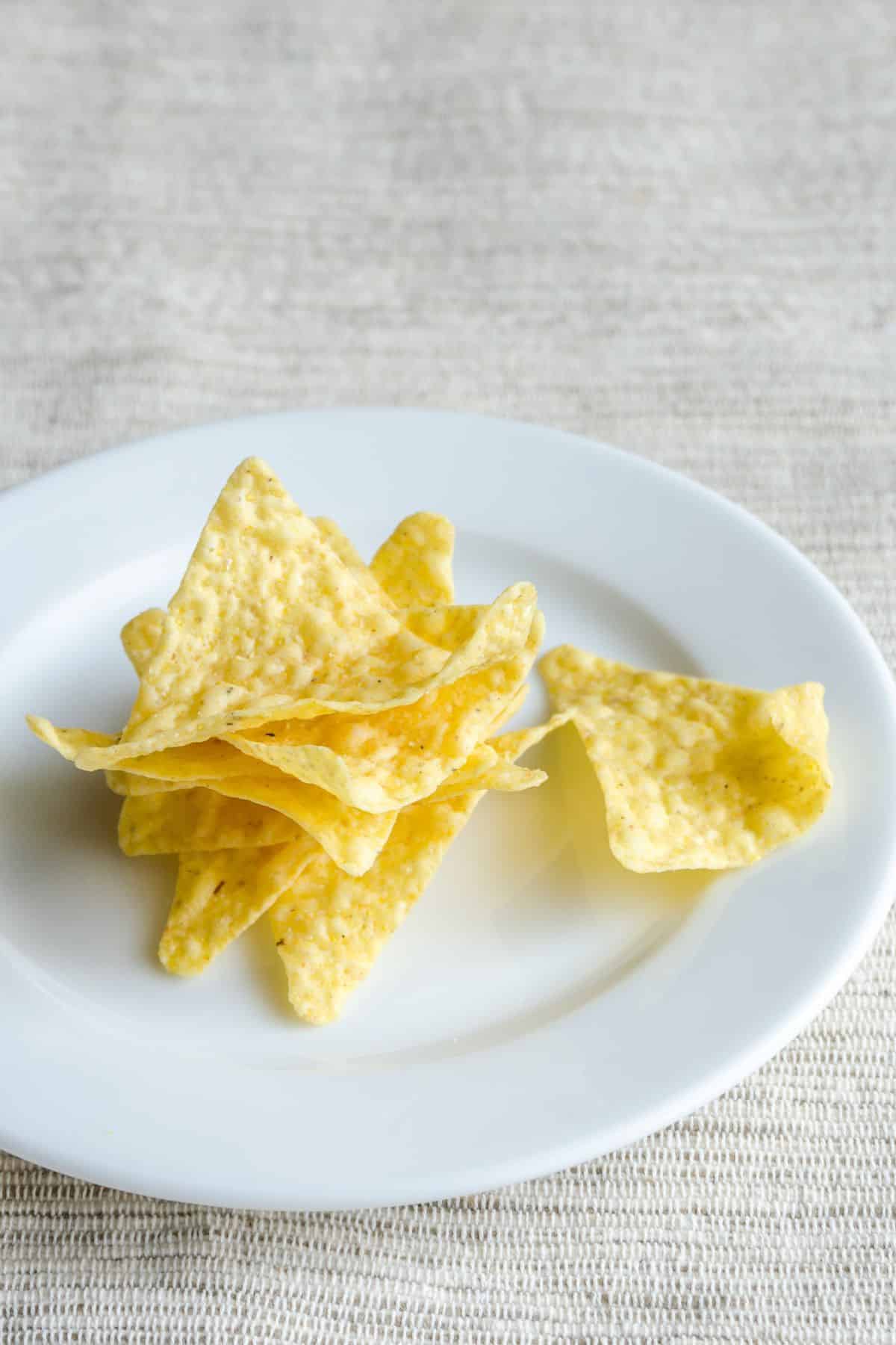 Plate with stack of yellow corn chips.