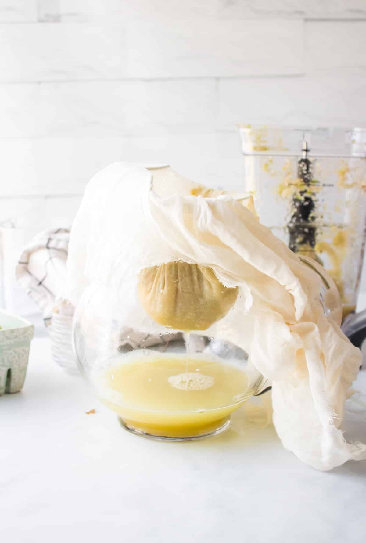 straining pear juice into pitcher.