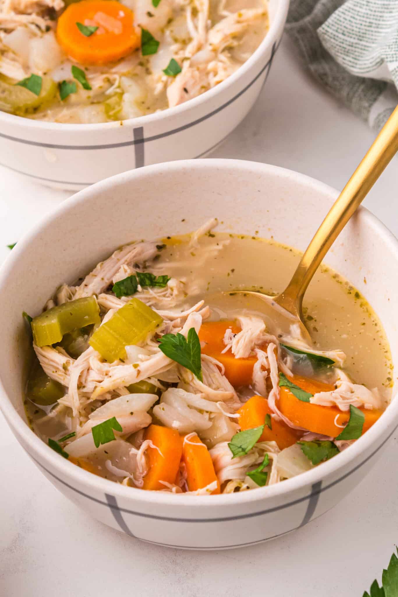 A small white bowl filled with homemade turkey vegetable soup.