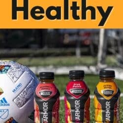 three bottles of Body Armor next to a volleyball.