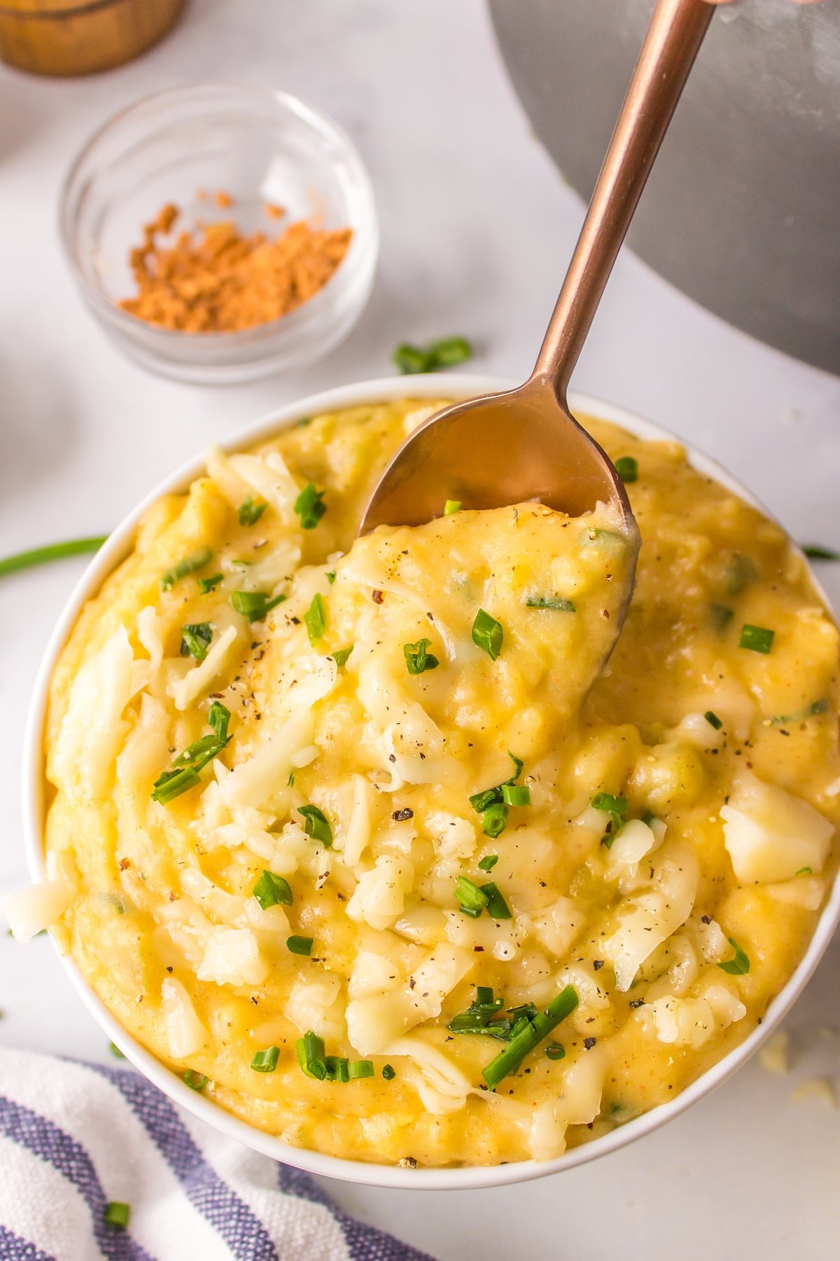 a spoon dipping into a bowl of Mexican mashed potatoes.