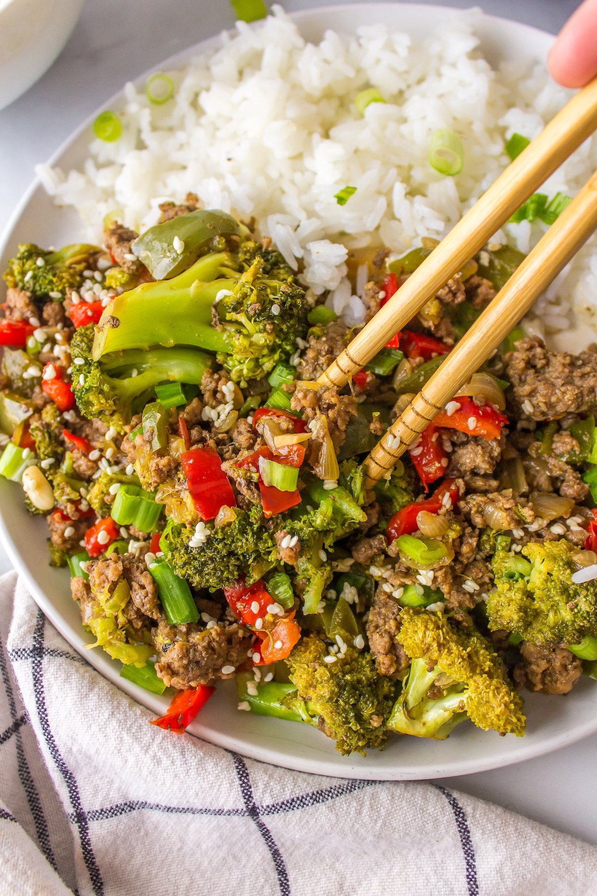 chop sticks picking up a bite of bison stir-fry.