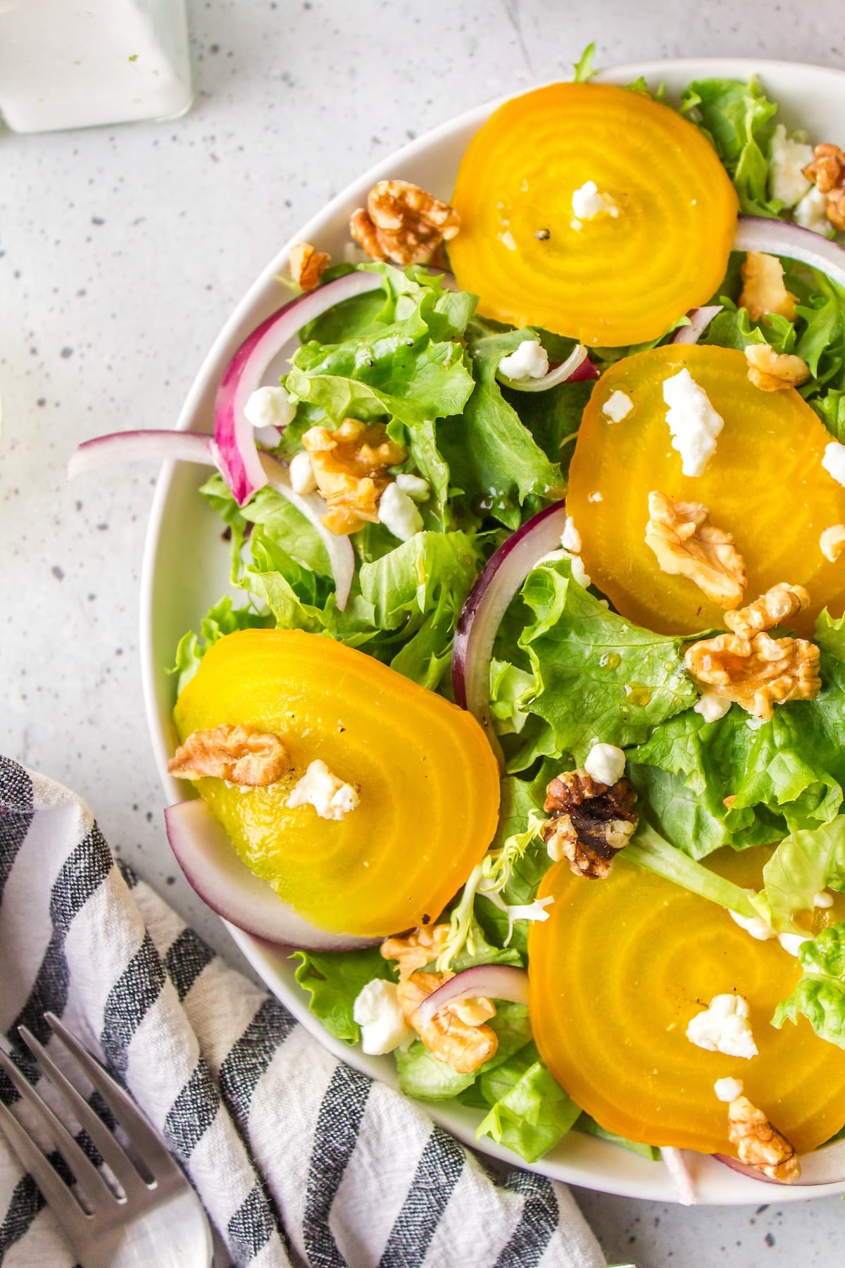 a white plate full of golden beet salad.