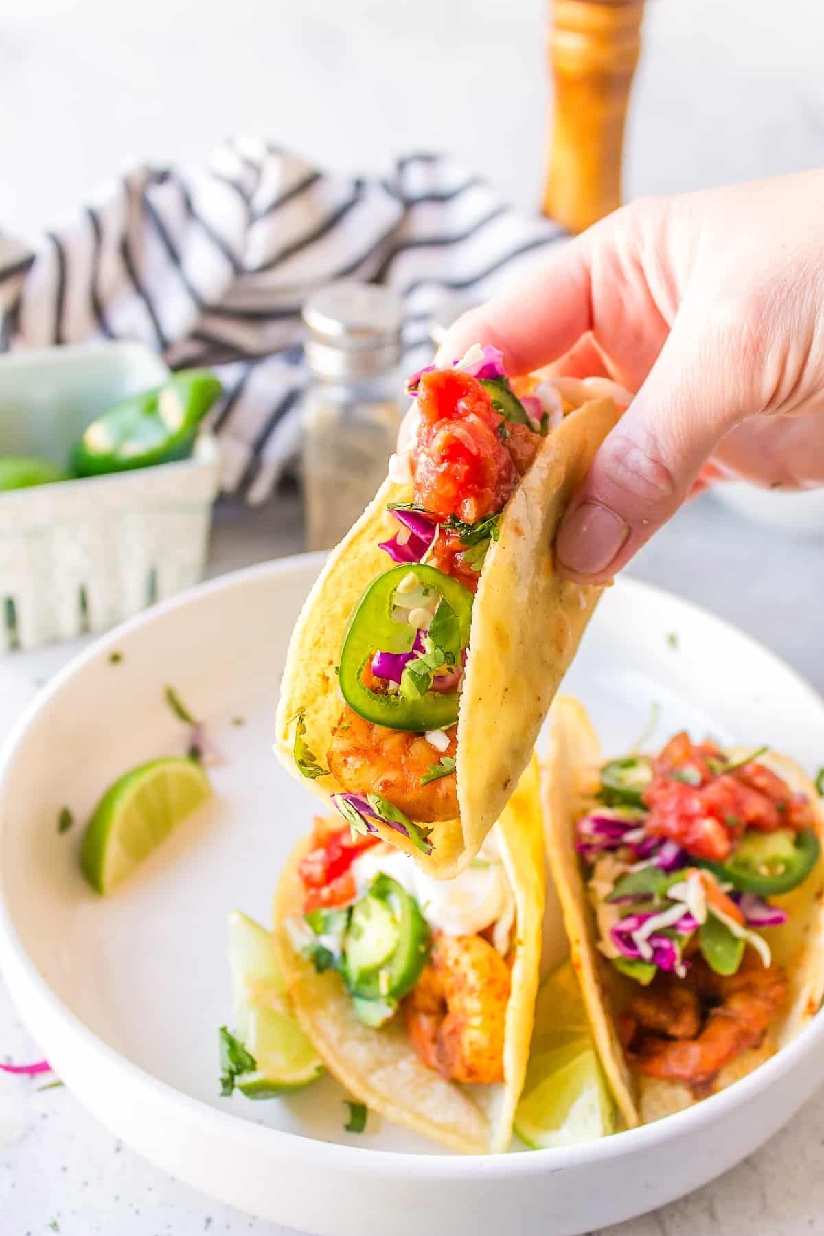 a person holding a baja shrimp taco.