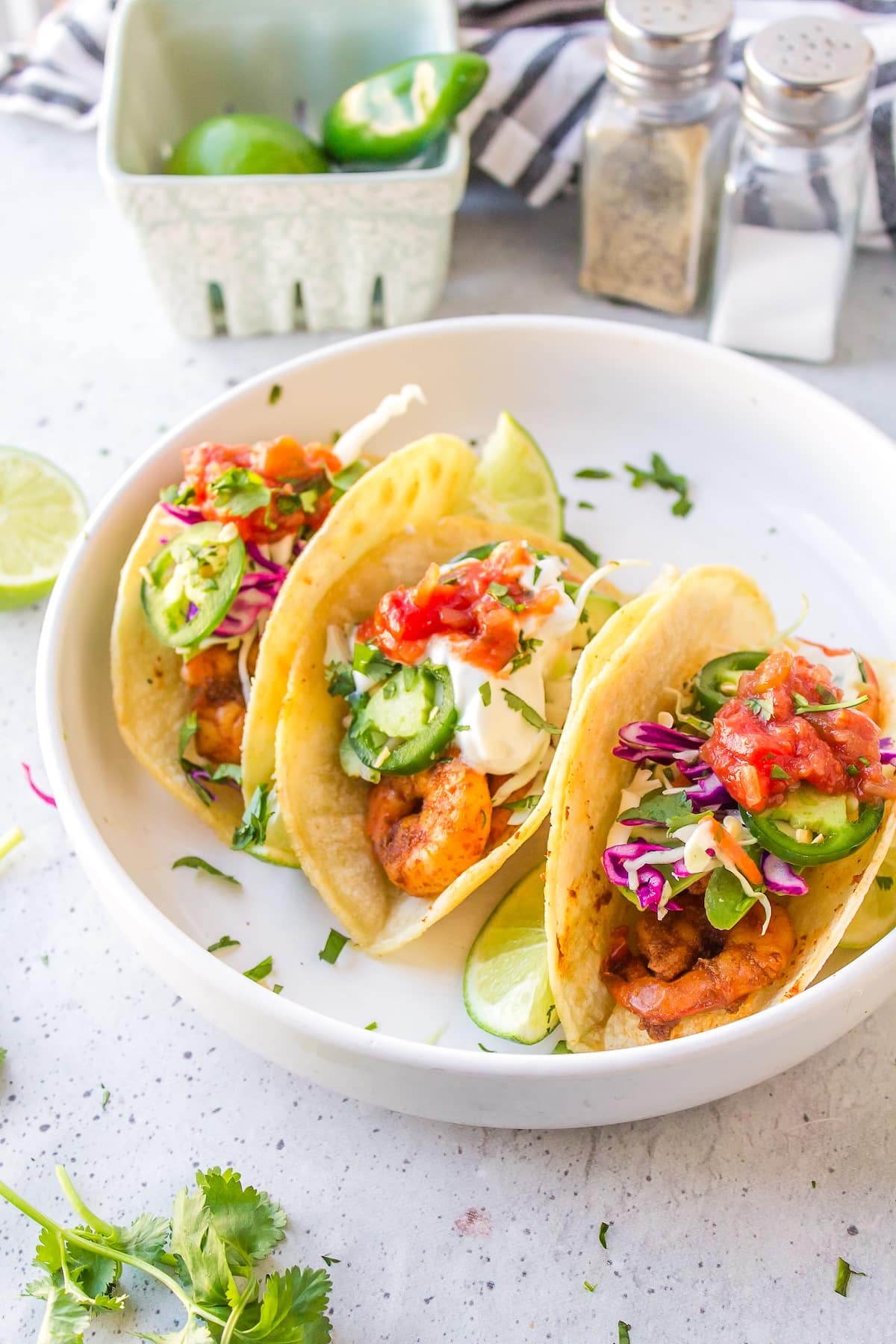 three baja shrimp tacos on a white plate.