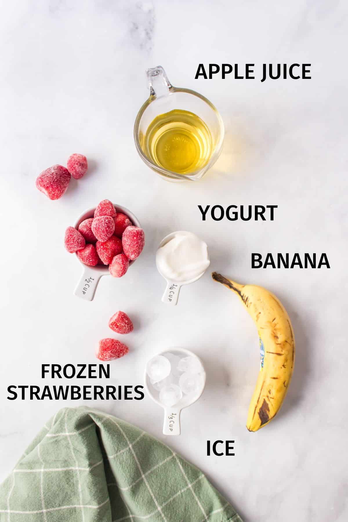 ingredients needed for a strawberry banana smoothie on a counter.