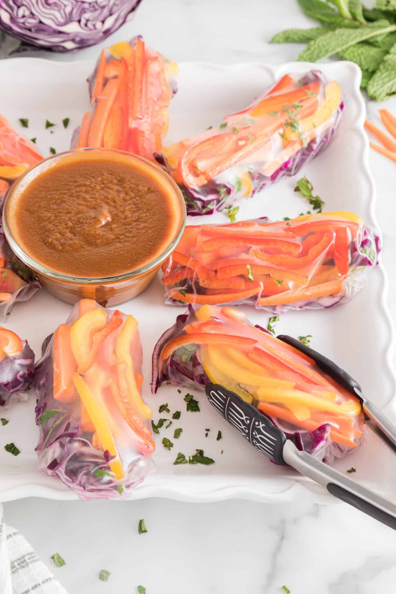 plate of vegan summer rolls with peanut dipping sauce.