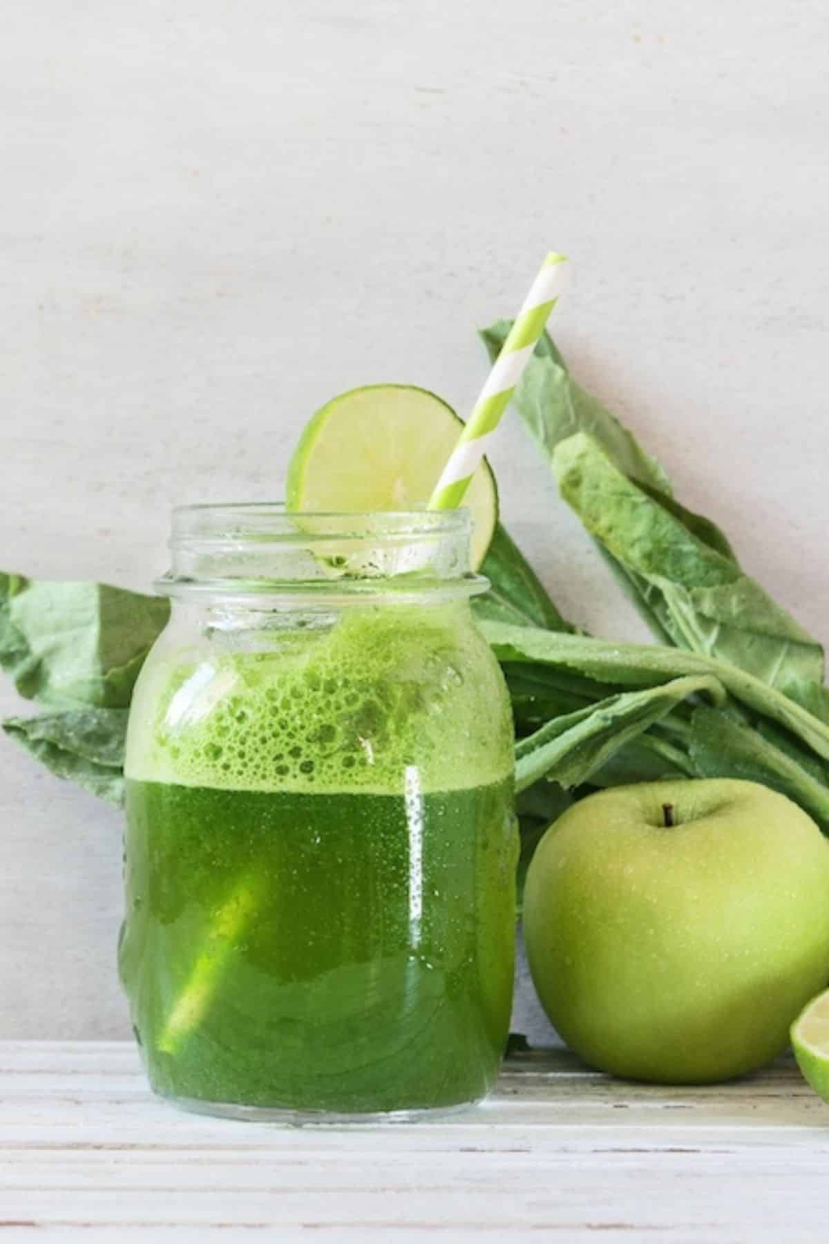 a glass of dandelion green juice with a straw.