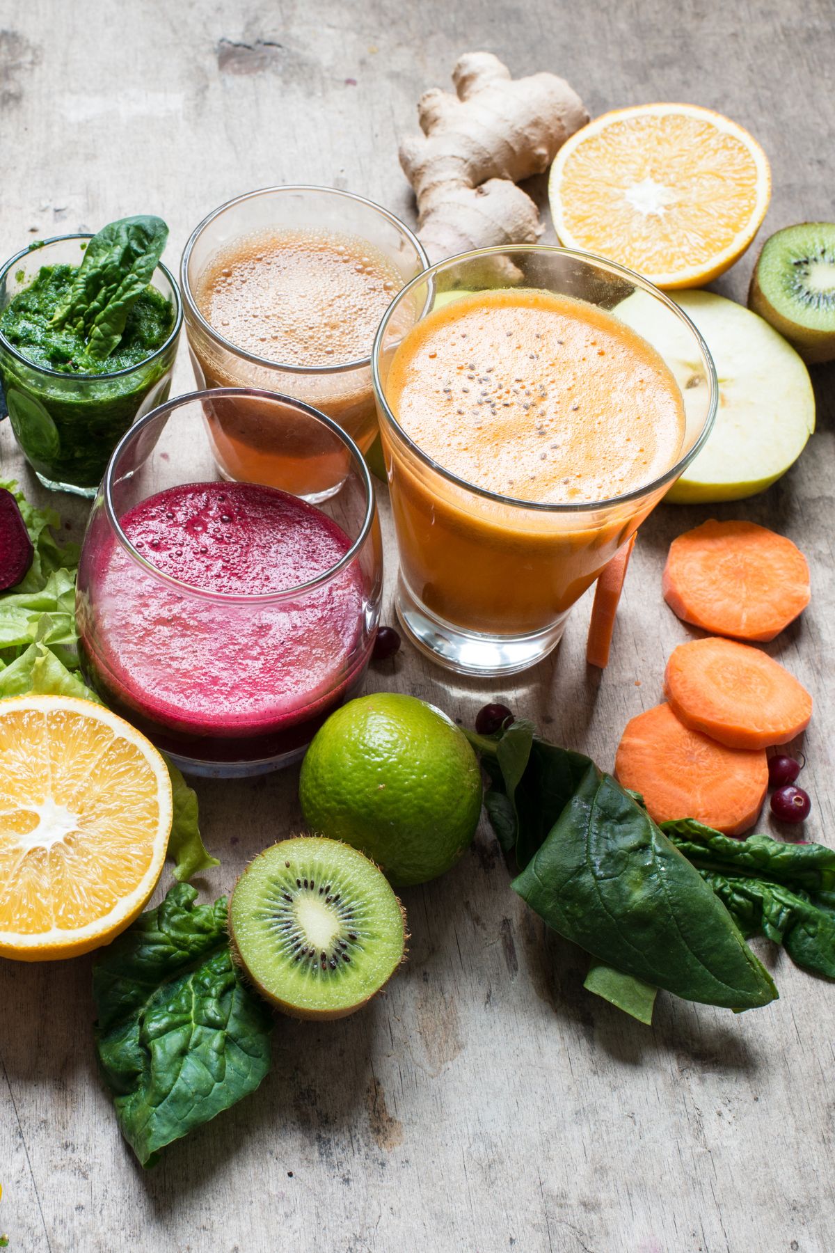 pretty vegetable juices on tabletop with produce.