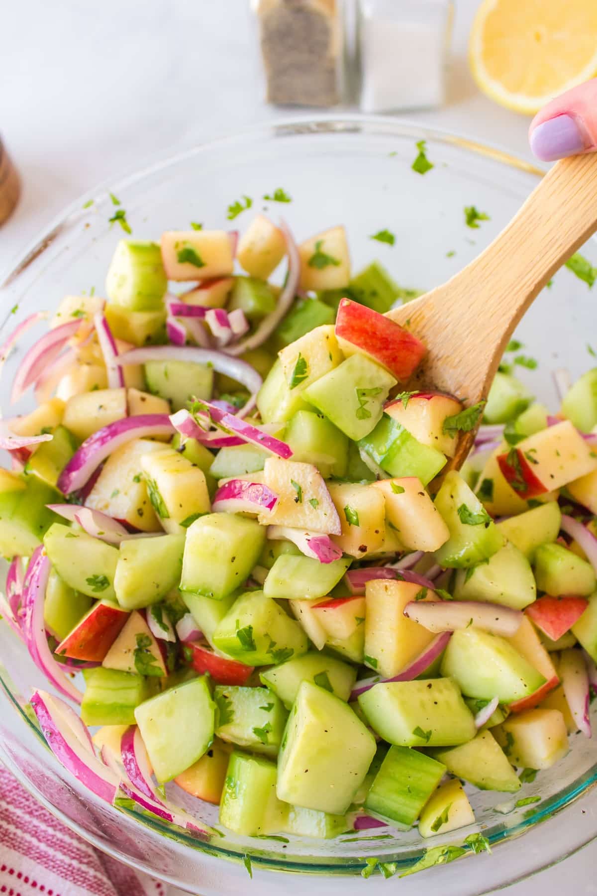 bowl of cucumber salad with serving spoon.