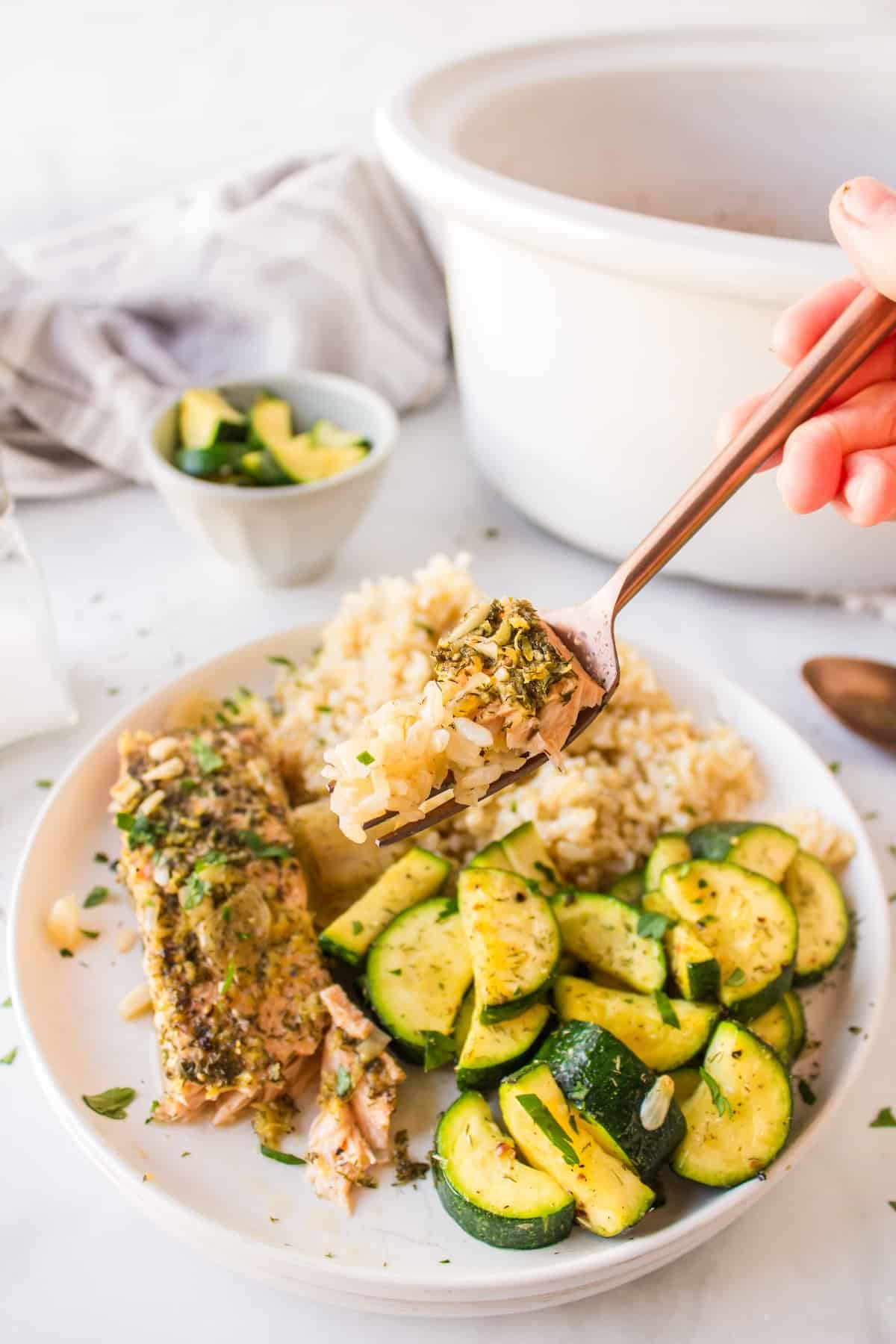 fork with a bite of crockpot salmon with rice.